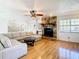 Spacious living room featuring a stone fireplace, hardwood floors, and a large sectional sofa at 9408 Oak St, Riverview, FL 33578