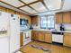 Kitchen boasts wood cabinets, white appliances, and a tiled floor at 9408 Oak St, Riverview, FL 33578