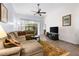 Bright living room with a comfortable sectional sofa and a view into a sunroom at 35506 Wickingham Ct, Zephyrhills, FL 33541