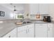 Kitchen with double sink and white cabinets at 35506 Wickingham Ct, Zephyrhills, FL 33541