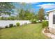 Spacious backyard with grassy area, white fence, and stone patio at 35506 Wickingham Ct, Zephyrhills, FL 33541
