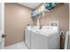 Well-equipped laundry room with washer, dryer, and storage shelves at 35506 Wickingham Ct, Zephyrhills, FL 33541