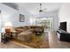 Spacious living room featuring a large sectional sofa and access to a relaxing sunroom at 35506 Wickingham Ct, Zephyrhills, FL 33541