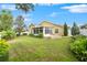 Large backyard with a yellow house and a screened porch at 35506 Wickingham Ct, Zephyrhills, FL 33541