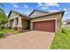 Single-Gathering home with brick driveway, two-car garage and palm trees at 10012 Sage Creek Dr, Ruskin, FL 33573