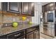 Stainless steel refrigerator and granite countertops in kitchen at 10012 Sage Creek Dr, Ruskin, FL 33573