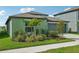 Green house with a two-car garage and nicely landscaped front yard at 13265 Great Plains Dr, Riverview, FL 33579