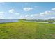 Spacious grassy backyard with pond view and white vinyl fence at 13265 Great Plains Dr, Riverview, FL 33579