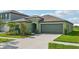 Single-story house with green exterior, two-car garage, and landscaped front yard at 13265 Great Plains Dr, Riverview, FL 33579