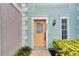 Inviting townhouse exterior with a vibrant orange door and well-maintained landscaping at 3364 W Wyoming Cir, Tampa, FL 33611