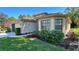 Well-maintained home with neat landscaping, an American flag, and a combination of lawn and garden beds at 11416 Billingham Blvd, Spring Hill, FL 34609