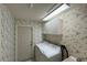 Laundry room with washer, dryer, cabinets, and floral wallpaper at 11416 Billingham Blvd, Spring Hill, FL 34609