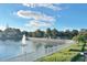 Scenic pond view with a fountain, white fence, and manicured hedges at 11416 Billingham Blvd, Spring Hill, FL 34609