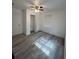 Well-lit bedroom with grey wood-look flooring and ceiling fan at 5238 16Th St, Zephyrhills, FL 33542