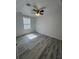 Spacious bedroom with grey wood-look flooring and ceiling fan at 5238 16Th St, Zephyrhills, FL 33542