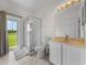 Bathroom with shower, toilet, vanity, and view of backyard from sliding door at 212 Excalibur Ct, Brandon, FL 33511
