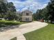 Two-story house with circular driveway, landscaping, and detached garage at 212 Excalibur Ct, Brandon, FL 33511