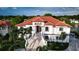 Luxury waterfront home with grand staircase and red tile roof at 8295 Cheyenne Dr, Seminole, FL 33777