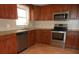 Kitchen with wood cabinets, granite countertops, and stainless steel appliances at 7101 Green St, New Port Richey, FL 34652