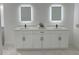 Modern bathroom featuring a double sink vanity with quartz countertops and lighted mirrors at 5308 Cedarshake Ln, Valrico, FL 33596