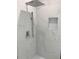 Close up of shower featuring marble tile, rain shower head, and built-in niche at 5308 Cedarshake Ln, Valrico, FL 33596