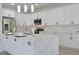 Modern kitchen island with white cabinets, quartz countertops and stainless steel appliances at 5308 Cedarshake Ln, Valrico, FL 33596