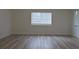 Bright bedroom with wood-look floors and window at 5308 Cedarshake Ln, Valrico, FL 33596