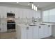 Bright kitchen featuring white shaker cabinets, quartz countertops, and a large island at 5308 Cedarshake Ln, Valrico, FL 33596