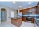 Inviting kitchen with stainless steel appliances, dark cabinets, granite counters, and an island at 5365 Shasta Daisy Pl, Land O Lakes, FL 34639