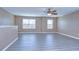 An airy living room featuring modern wood-look flooring and a ceiling fan at 5365 Shasta Daisy Pl, Land O Lakes, FL 34639