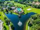 Aerial view of the community pool and lake featuring playground and picnic pavilion at 5365 Shasta Daisy Pl, Land O Lakes, FL 34639