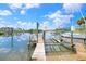 Private boat dock featuring a boat lift and a picturesque view of the calm waterway at 944 Apollo Beach Blvd, Apollo Beach, FL 33572