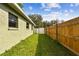 Long backyard with grassy area, wooden fence, and gate at 7024 Filbert Ln, Tampa, FL 33637