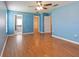 Large bedroom with wood floors, ceiling fan, and access to bathroom at 18933 Sunterra Dr, Land O Lakes, FL 34638