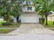 Two-story house with a white garage door and landscaping at 18933 Sunterra Dr, Land O Lakes, FL 34638