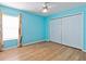 Bedroom with light-blue walls, wood flooring, and double-door closet at 18933 Sunterra Dr, Land O Lakes, FL 34638