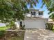 Two-story house with a white garage door and landscaping at 18933 Sunterra Dr, Land O Lakes, FL 34638