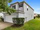 Two-story house with a white garage door and landscaping at 18933 Sunterra Dr, Land O Lakes, FL 34638