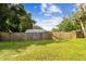 Large grassy backyard with wooden fence and storage shed at 7024 Filbert Ln, Tampa, FL 33637