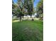 Grass backyard with mature trees and distant golf course view at 18135 Canal Pointe St, Tampa, FL 33647