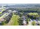 Aerial view shows a golf course community with manicured lawns and tree coverage at 13451 Knotty Ln, Hudson, FL 34669