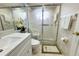 Bathroom features shower with glass doors, vanity with white countertop, and a decorative floral accent at 13451 Knotty Ln, Hudson, FL 34669