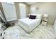 Bright bedroom features a queen-sized bed, large windows, and marble tile flooring at 13451 Knotty Ln, Hudson, FL 34669