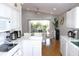 Bright, open kitchen features marble countertops, white cabinetry and stainless steel appliances at 13451 Knotty Ln, Hudson, FL 34669