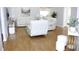 Spacious living room featuring hardwood floors, white leather furniture, and modern decor at 13451 Knotty Ln, Hudson, FL 34669