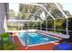 Inviting screened pool with lush landscaping, lounge chairs, and covered lanai area at 13451 Knotty Ln, Hudson, FL 34669