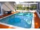 Relaxing screened pool with surrounding patio area and comfortable lounge seating at 13451 Knotty Ln, Hudson, FL 34669