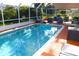 Screened pool area with lounge chairs, lush greenery, and tranquil setting at 13451 Knotty Ln, Hudson, FL 34669