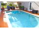 Inviting pool area with lounge seating, patio, and serene backyard views at 13451 Knotty Ln, Hudson, FL 34669