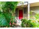 Red front door entrance with lush tropical landscaping at 758 Pine Run Dr # 758, Osprey, FL 34229